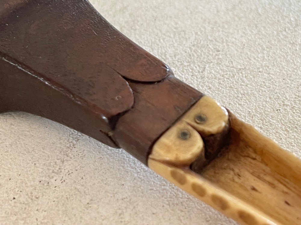 A Georgian treen apple corer featuring a dark mahogany handle joined to a carved bone scoop with metal pins. View VII