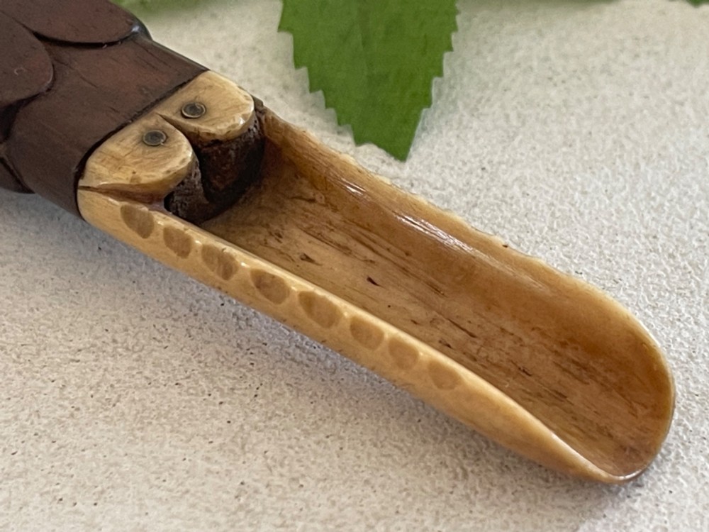 A Georgian treen apple corer featuring a dark mahogany handle joined to a carved bone scoop with metal pins. View VIII