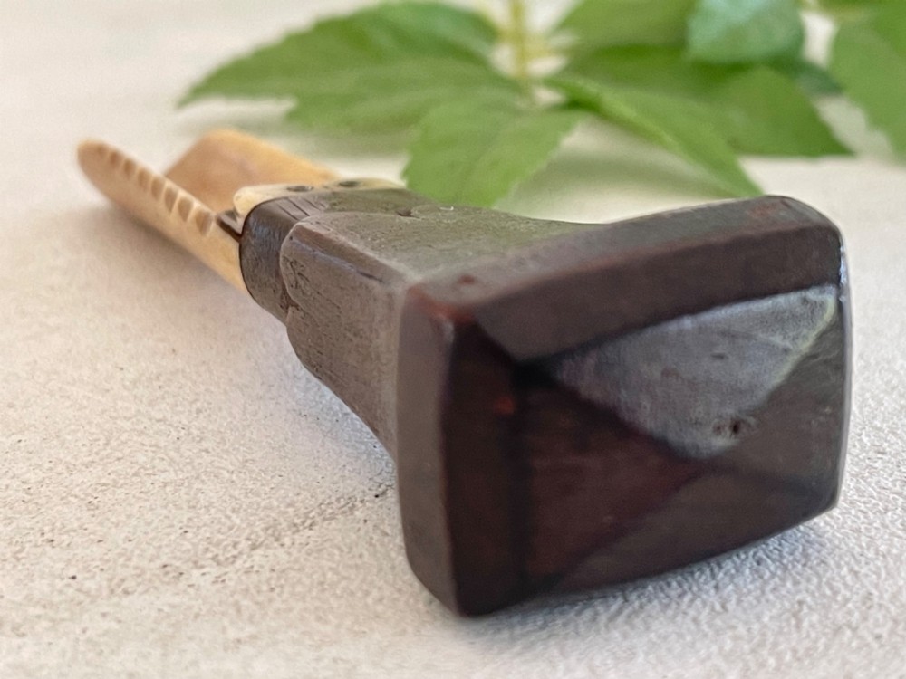 A Georgian treen apple corer featuring a dark mahogany handle joined to a carved bone scoop with metal pins. View IX