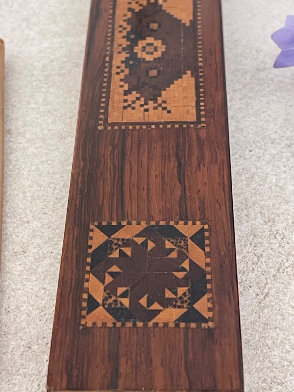 A long rectangular dark rosewood silk skein holder featuring a central band of intricate geometric tessellated wood inlay. View IV