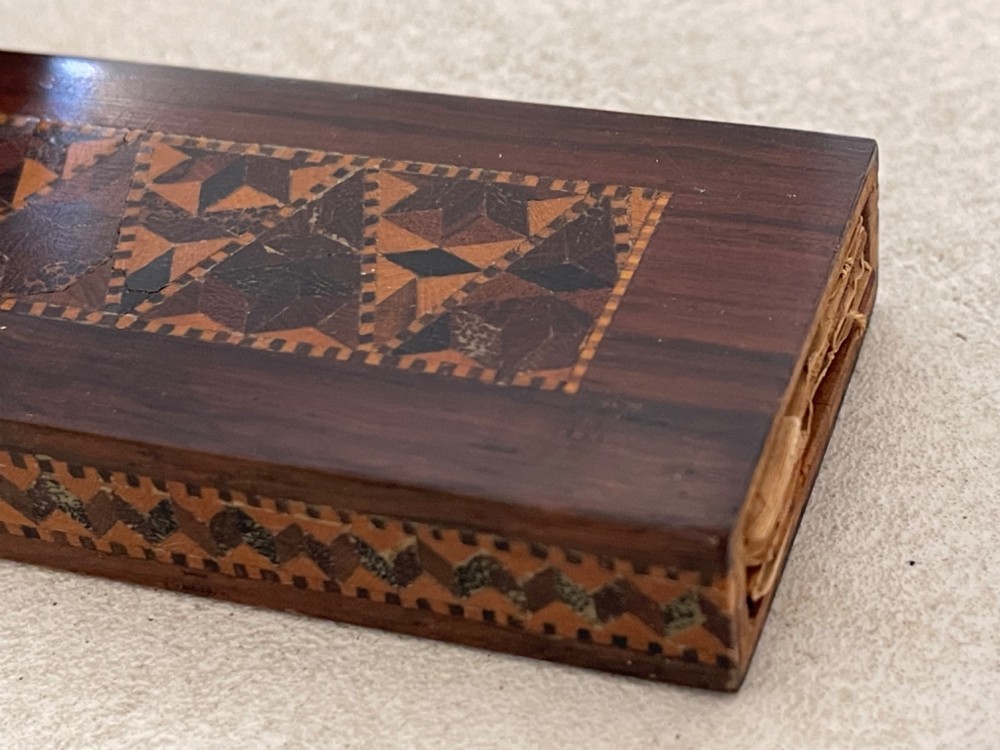 A long rectangular dark rosewood silk skein holder featuring a central band of intricate geometric tessellated wood inlay. View VI