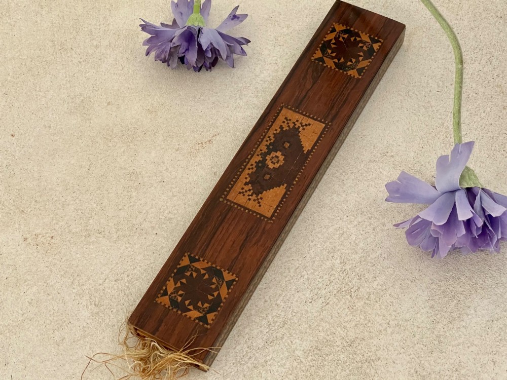 A long rectangular dark rosewood silk skein holder featuring a central band of intricate geometric tessellated wood inlay. View VIII
