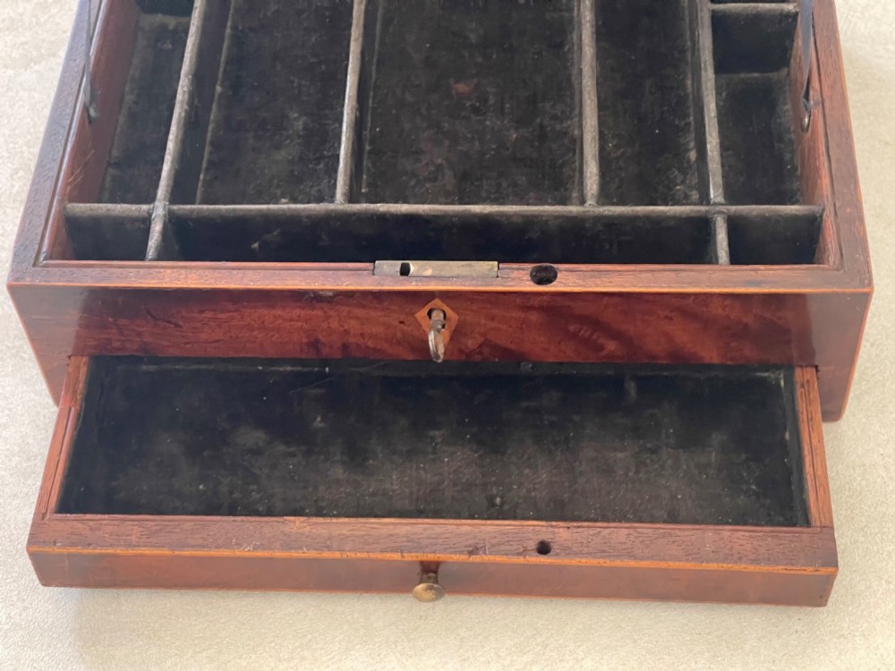 A rectangular Georgian flame mahogany jewellery box featuring a lower drawer, brass knob, and diamond inlay escutcheon. View III