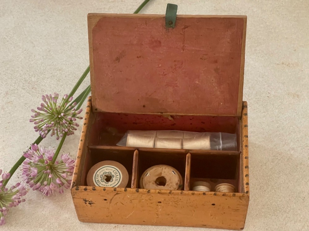 An antique Georgian wooden reel box painted in warm ochre with a floral motif on the lid and thread apertures along the front. View IV