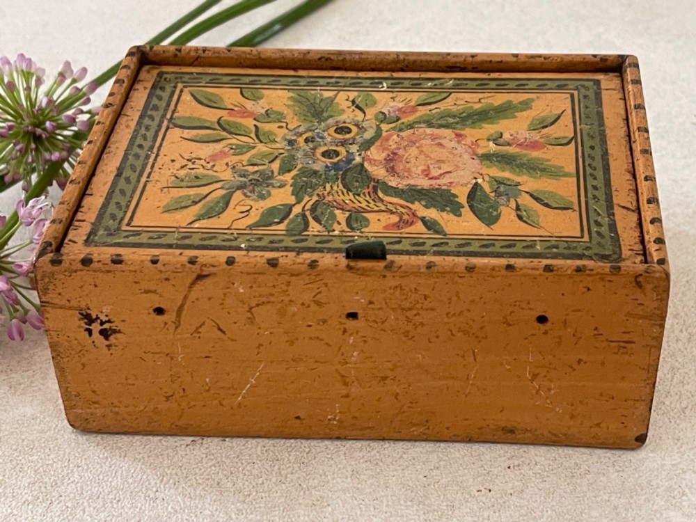 An antique Georgian wooden reel box painted in warm ochre with a floral motif on the lid and thread apertures along the front. View VI
