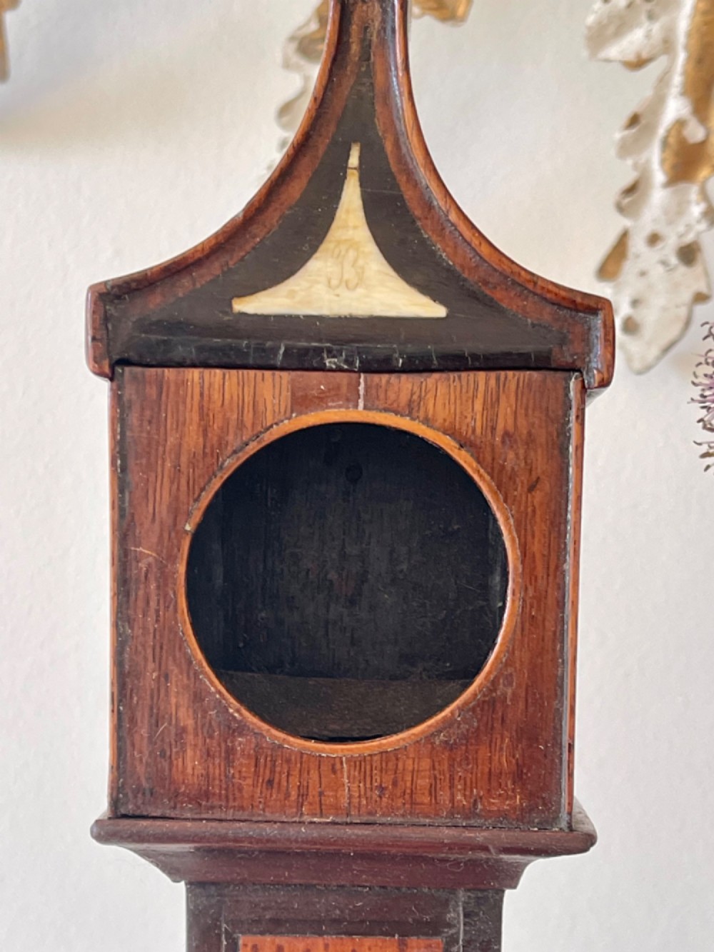 A Georgian treen pocket watch holder shaped as a miniature longcase clock with mahogany timber and floral marquetry inlay. View V