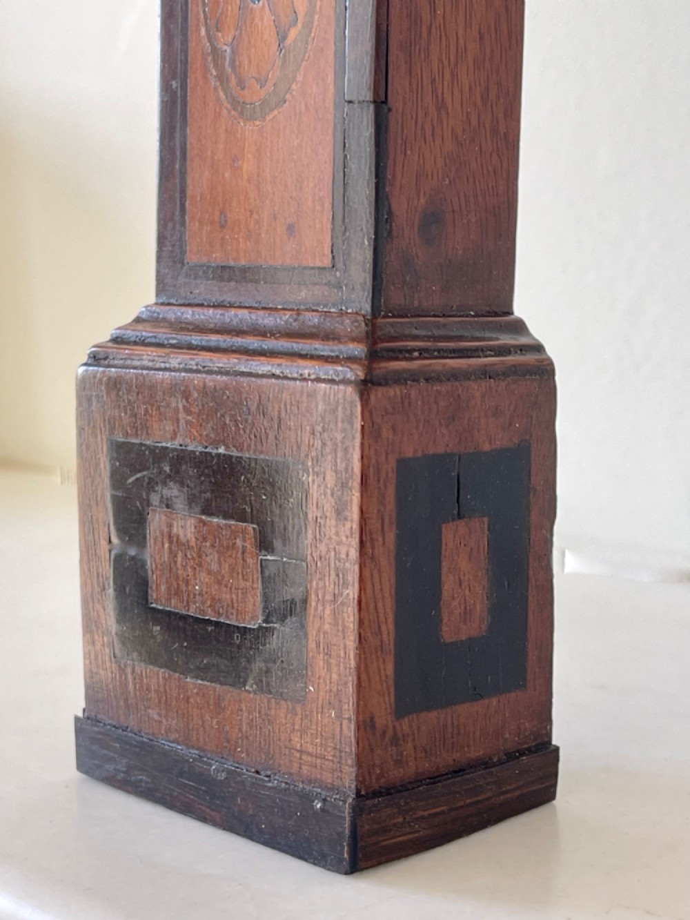 A Georgian treen pocket watch holder shaped as a miniature longcase clock with mahogany timber and floral marquetry inlay. View VIII
