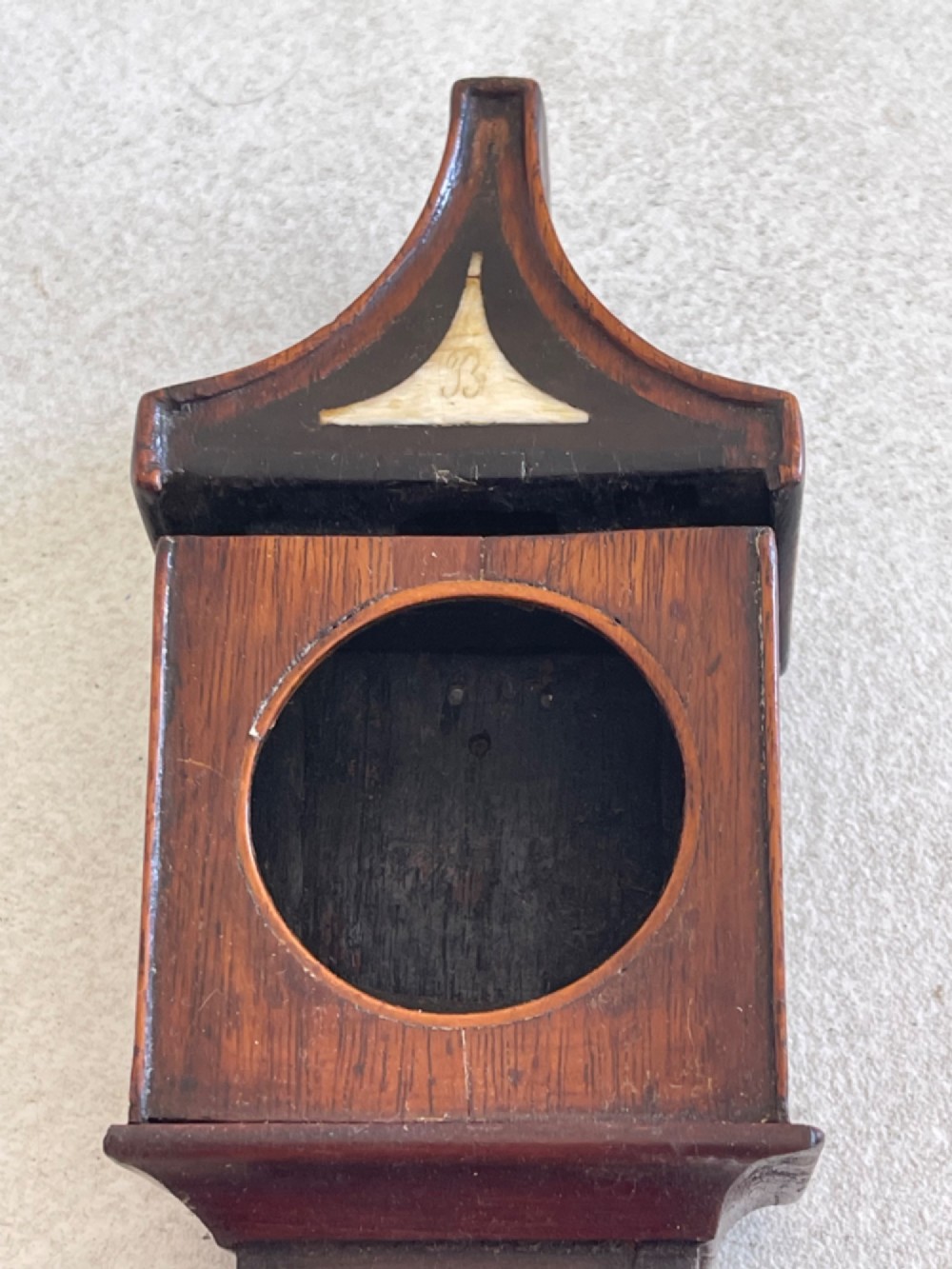 A Georgian treen pocket watch holder shaped as a miniature longcase clock with mahogany timber and floral marquetry inlay. View XI