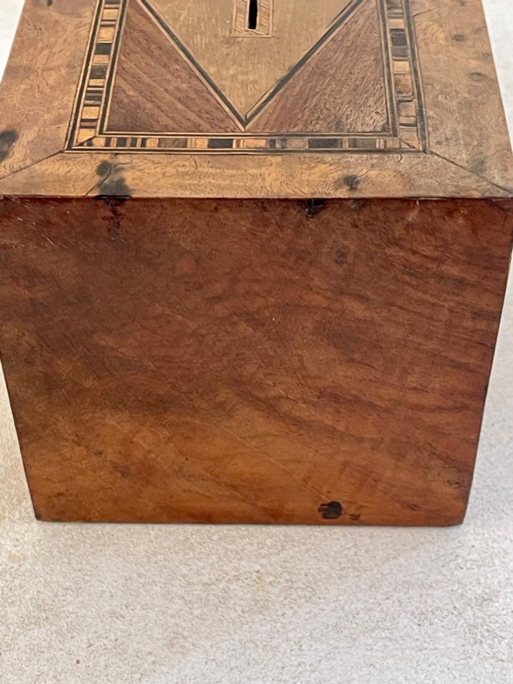 A rectangular mahogany money box featuring an inlaid wooden marquetry panel depicting a steamship at sea alongside a lighthouse. View VI
