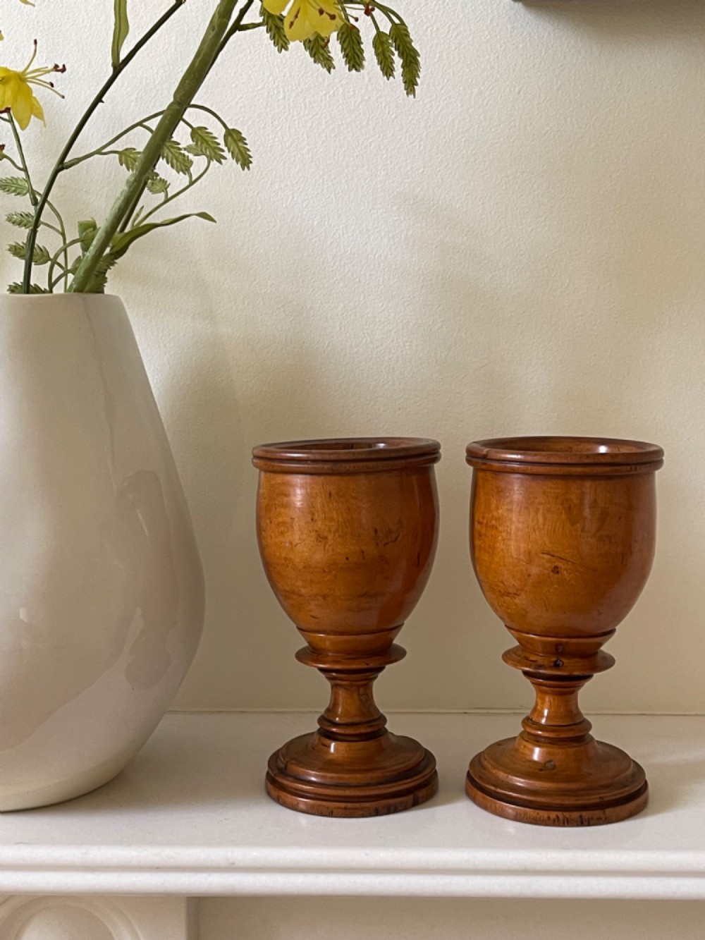 A pair of turned fruitwood goblets featuring knopped stems and stepped circular bases set against a plain background. View IV