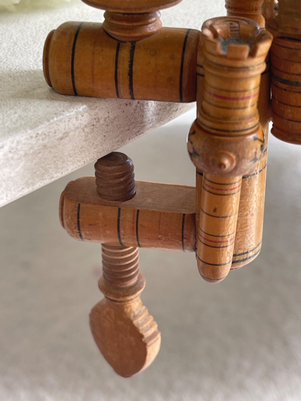 A Georgian turned wood sewing clamp featuring an upper pincushion cup, threaded wooden clamp mechanism, painted line decoration, and matching wooden needle cases. View V