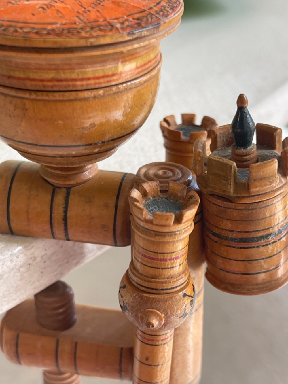 A Georgian turned wood sewing clamp featuring an upper pincushion cup, threaded wooden clamp mechanism, painted line decoration, and matching wooden needle cases. View VI