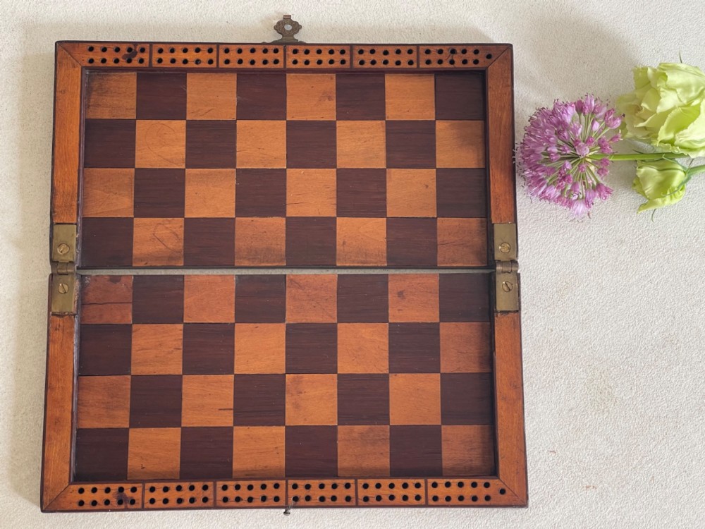 A rectangular Georgian folding wooden games board featuring central oval shell marquetry inlay, crossbanded borders, and a brass latch on the side. View II