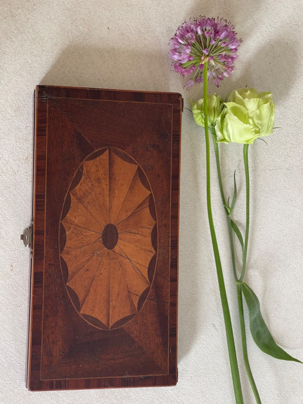 A rectangular Georgian folding wooden games board featuring central oval shell marquetry inlay, crossbanded borders, and a brass latch on the side. View III