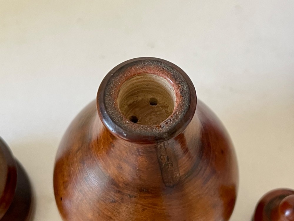 A turned brown hardwood spice flask featuring a bulbous body, finial stopper, and a stepped circular pedestal base. View II