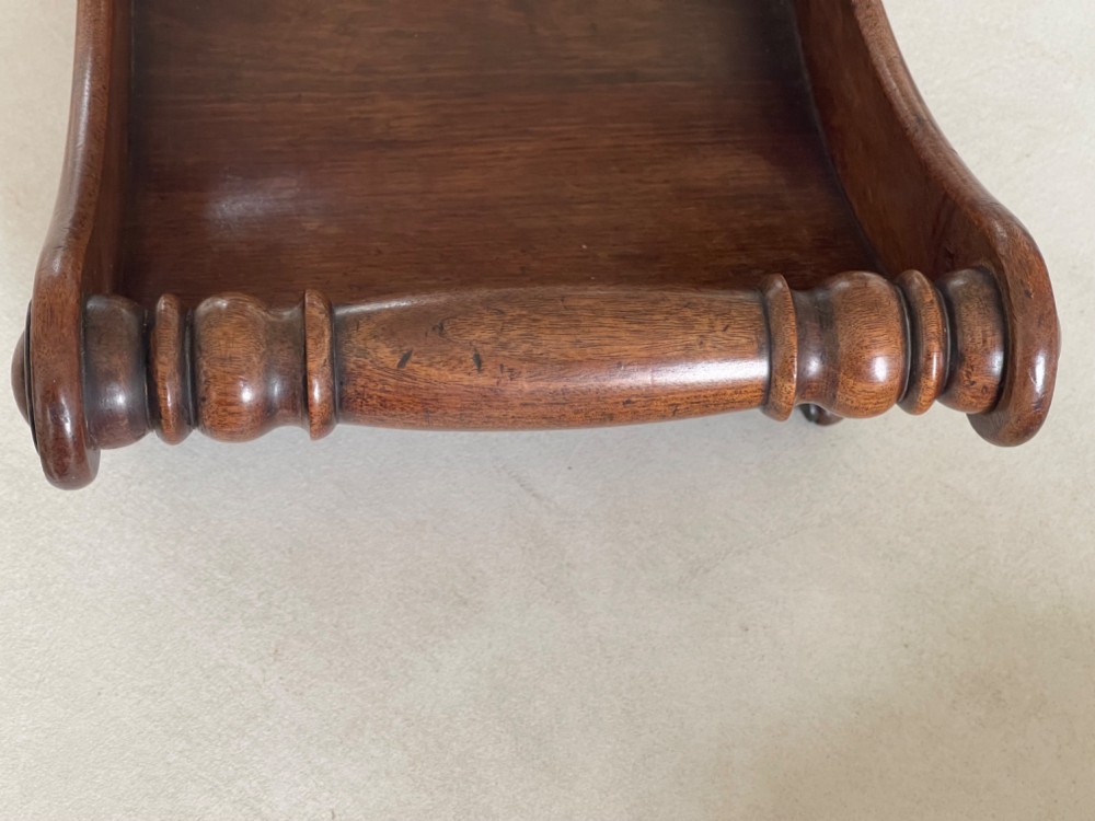 A curved Georgian mahogany cheese coaster with turned end handles and small brass castors on the base. View IV