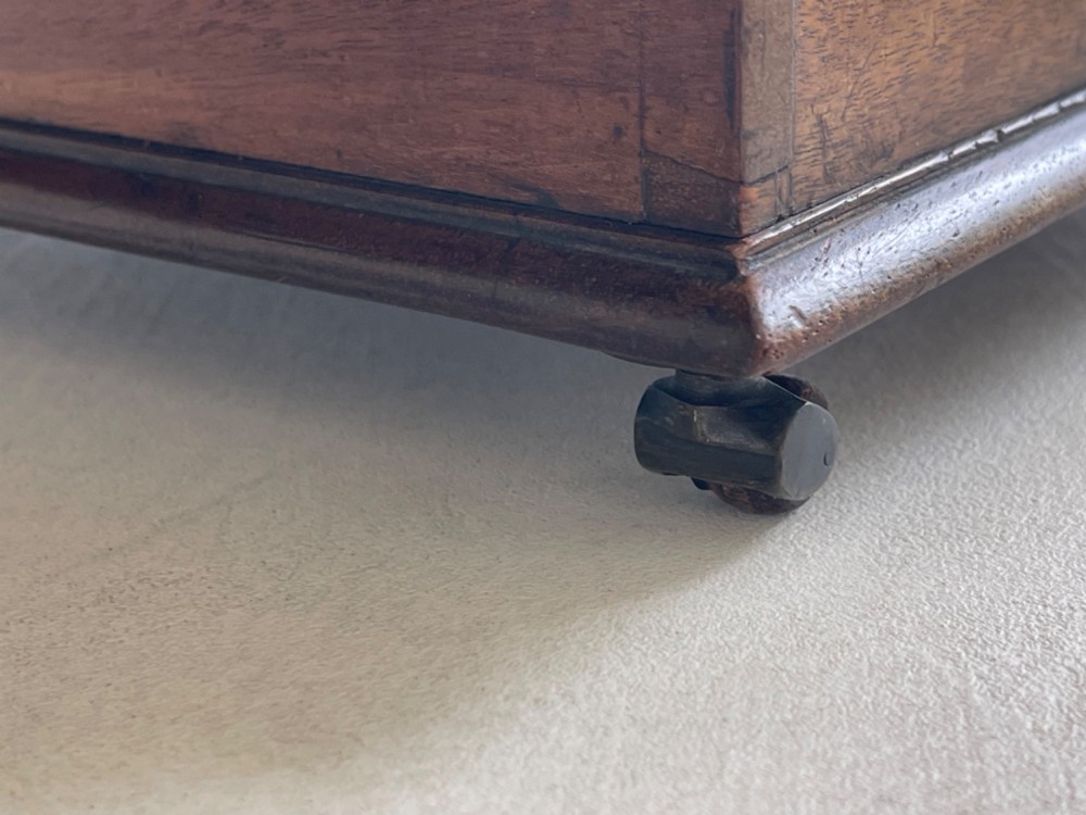 A curved Georgian mahogany cheese coaster with turned end handles and small brass castors on the base. View VI