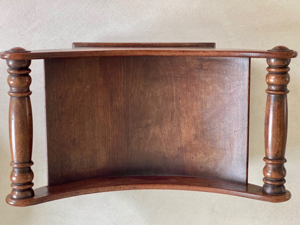 A curved Georgian mahogany cheese coaster with turned end handles and small brass castors on the base. View VII