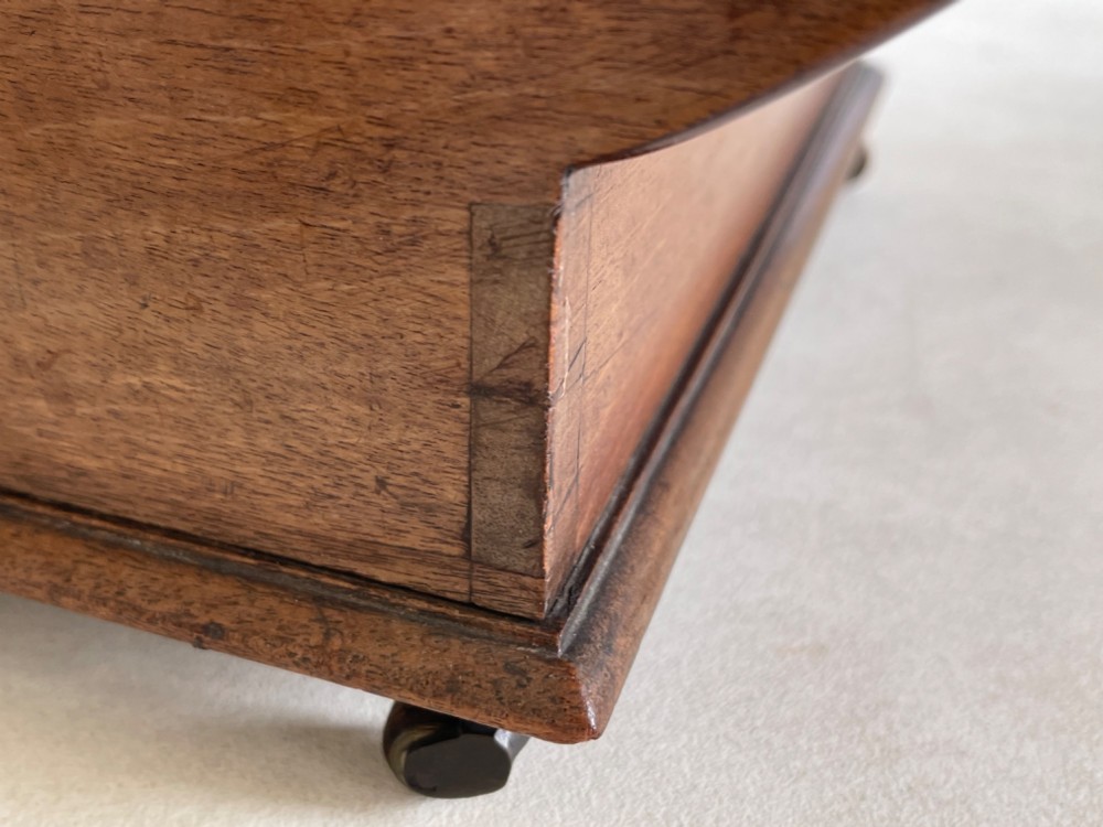A curved Georgian mahogany cheese coaster with turned end handles and small brass castors on the base. View VIII