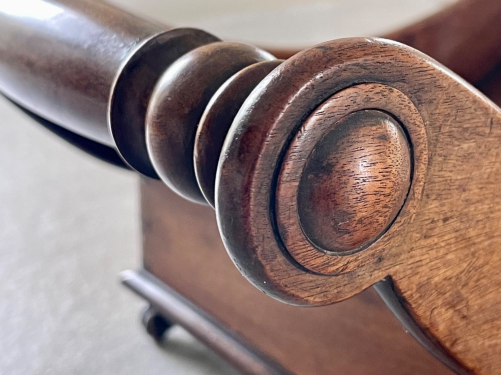 A curved Georgian mahogany cheese coaster with turned end handles and small brass castors on the base. View IX