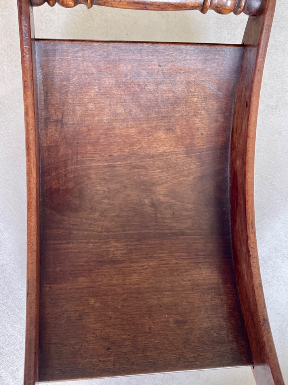 A curved Georgian mahogany cheese coaster with turned end handles and small brass castors on the base. View X