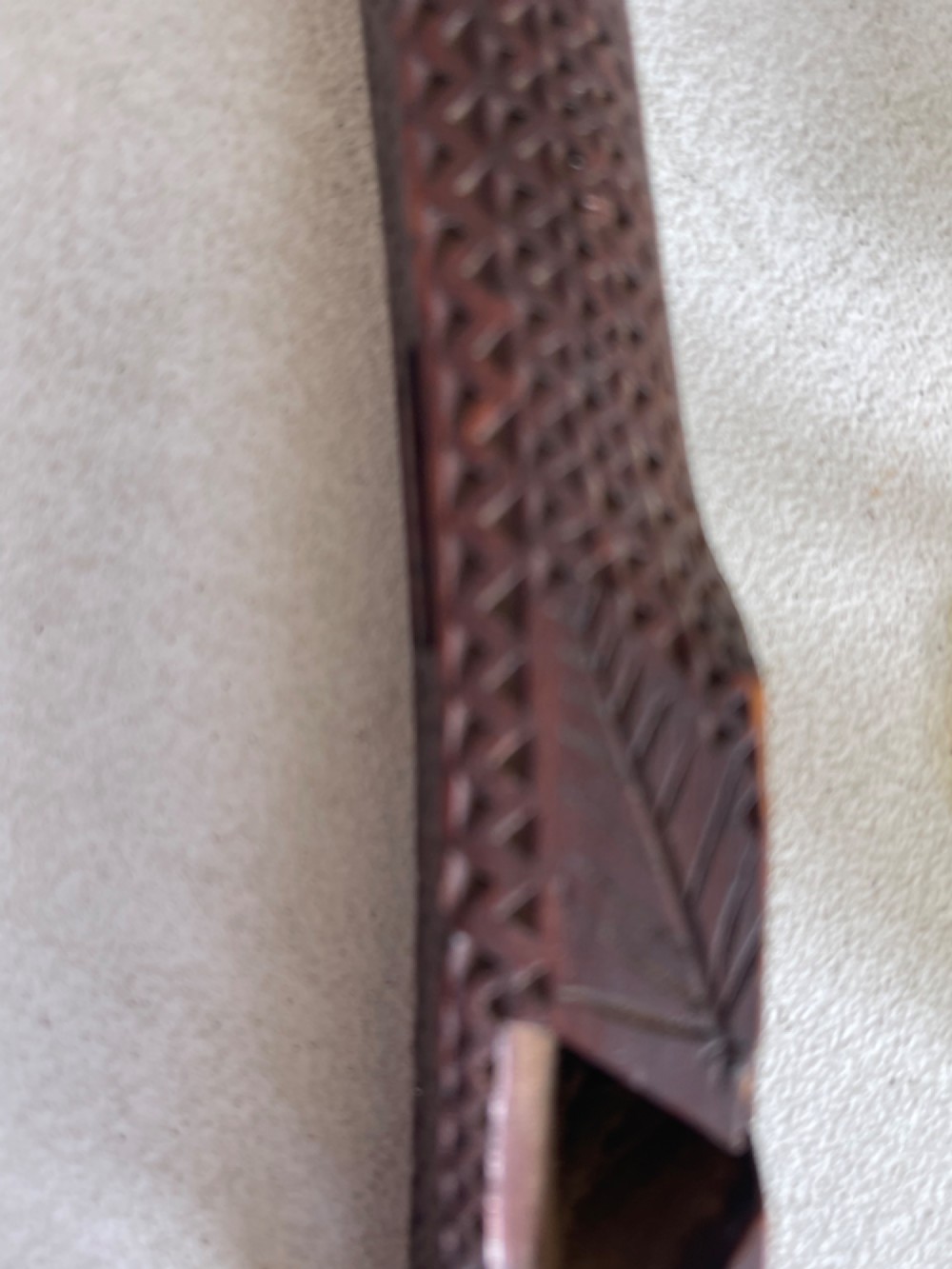 A dark hand-carved wooden treen knitting sheath featuring geometric chip carving, a ball-in-cage detail, and a carved heart motif. View V