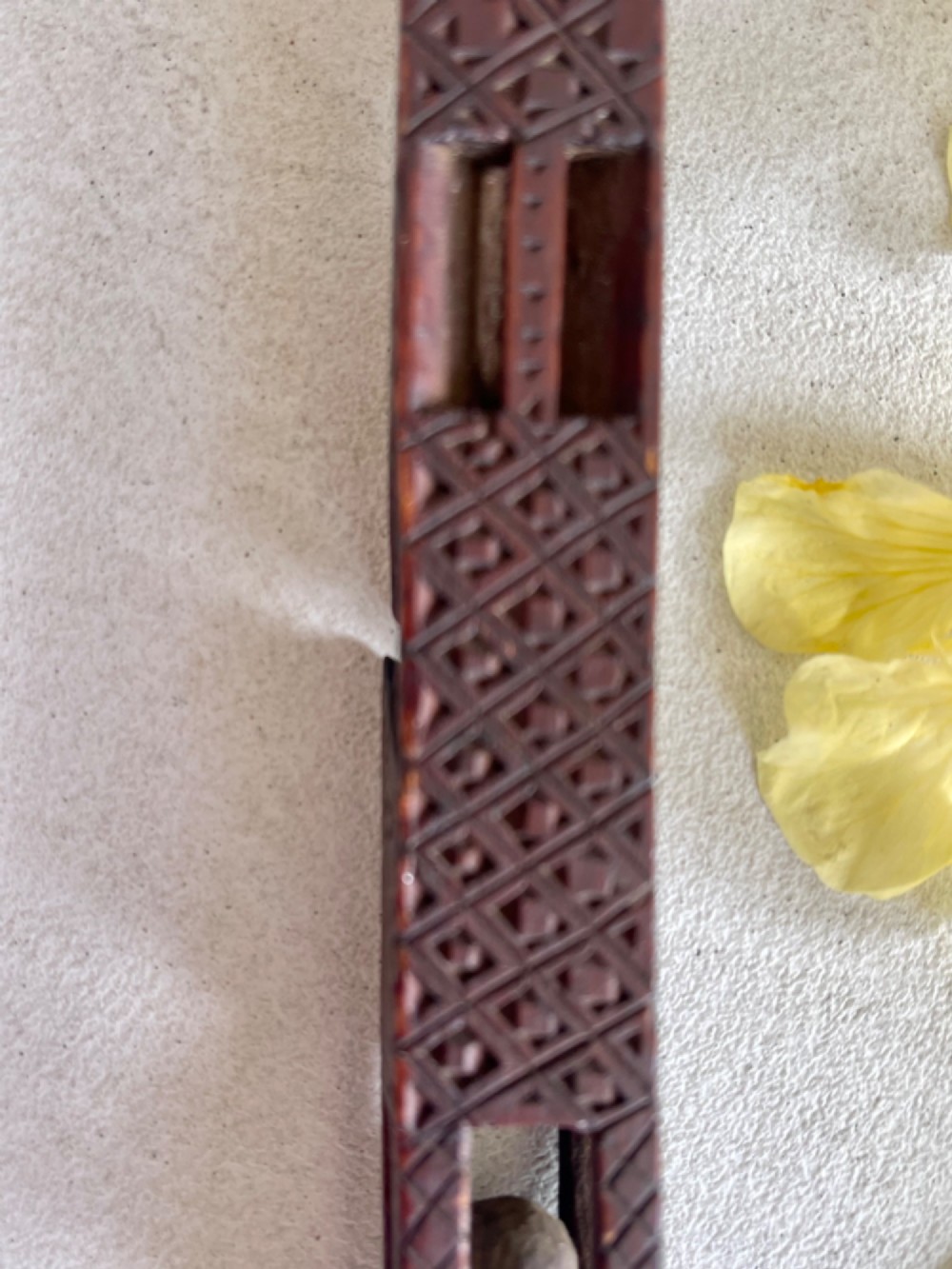 A dark hand-carved wooden treen knitting sheath featuring geometric chip carving, a ball-in-cage detail, and a carved heart motif. View VI