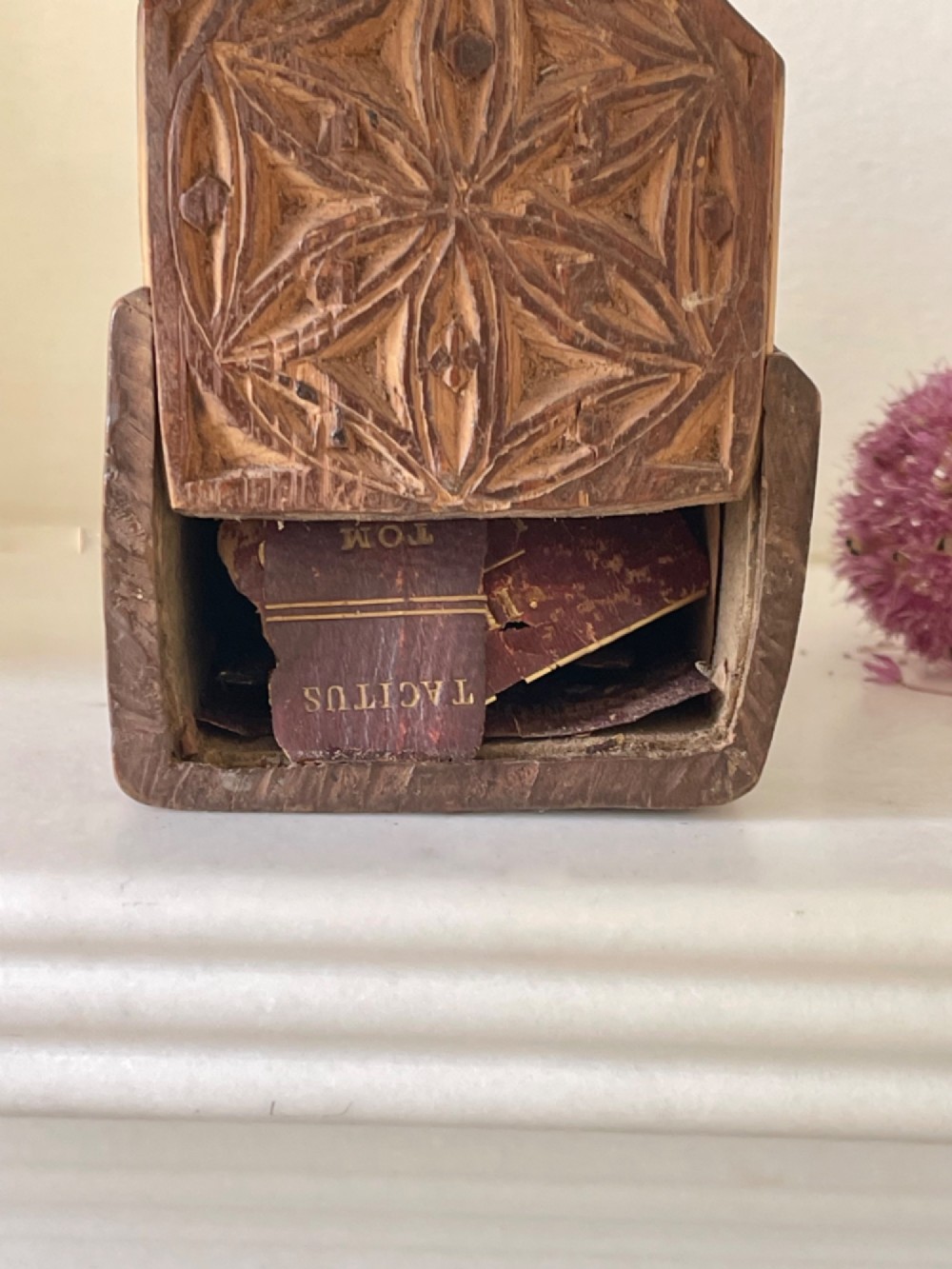 A small hand-carved warm brown wooden box featuring geometric chip-carved starburst motifs and upright carved finials. View III