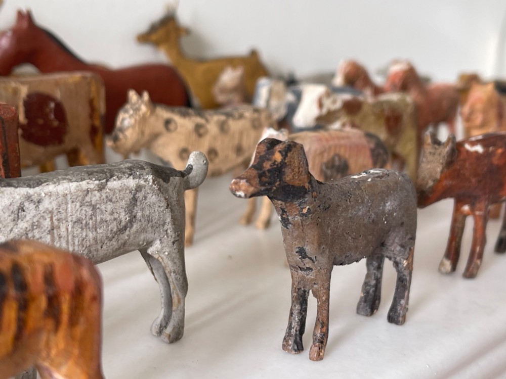 A hand-painted 19th-century wooden Noahs ark toy with a pitched roof and painted windows, accompanied by carved wooden figures. View V