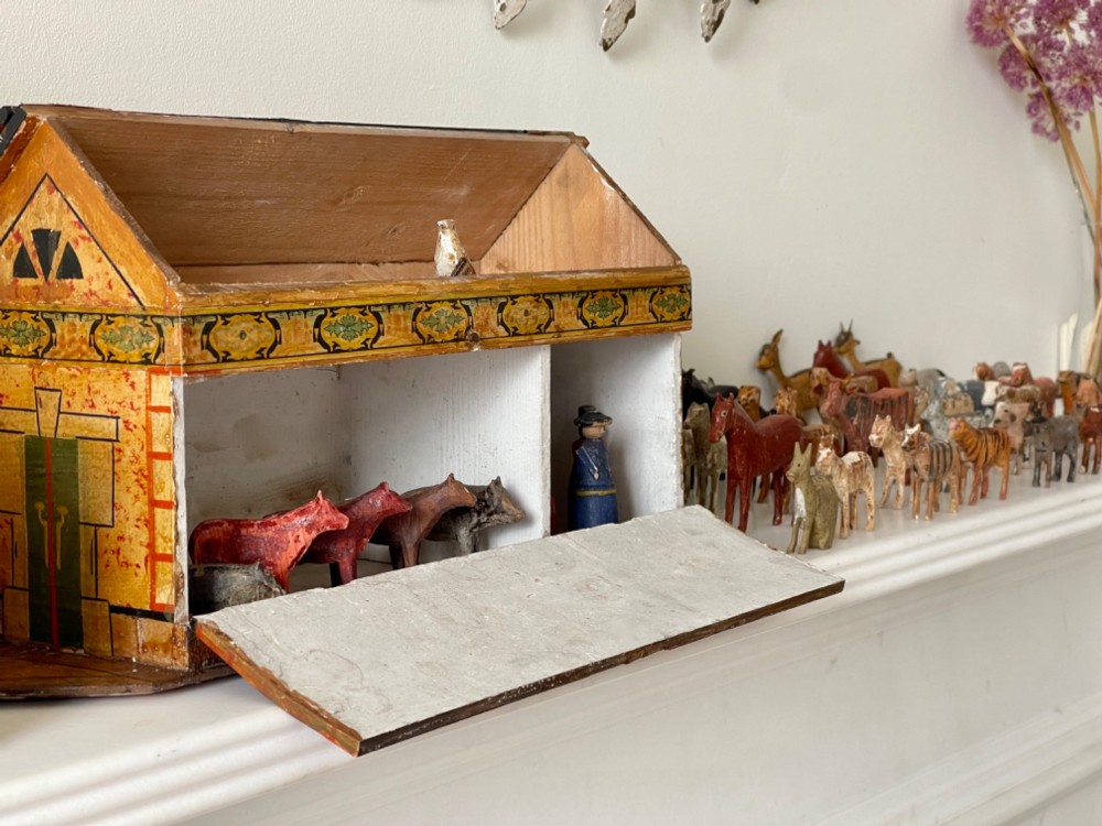 A hand-painted 19th-century wooden Noahs ark toy with a pitched roof and painted windows, accompanied by carved wooden figures. View VI