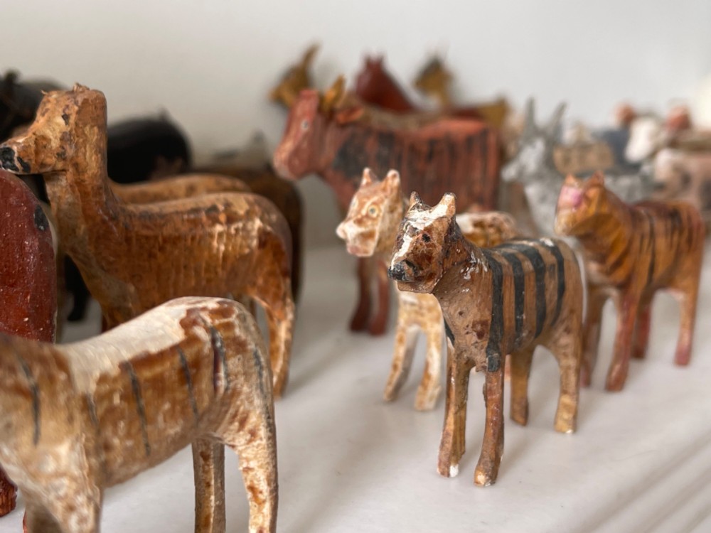 A hand-painted 19th-century wooden Noahs ark toy with a pitched roof and painted windows, accompanied by carved wooden figures. View XI