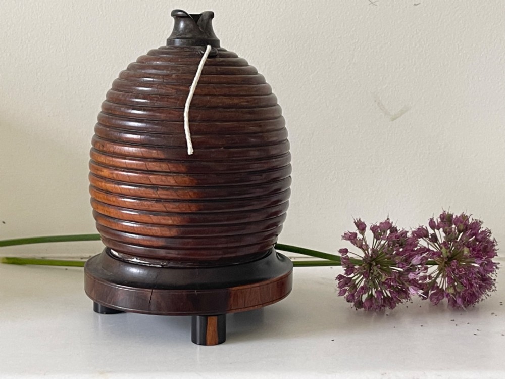 A turned brown wooden string box shaped like a beehive skep with a metal cutter top resting on small feet. View II