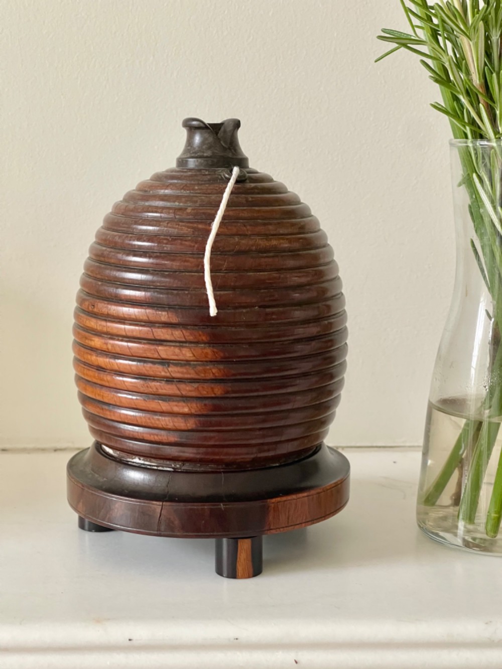 A turned brown wooden string box shaped like a beehive skep with a metal cutter top resting on small feet. View III
