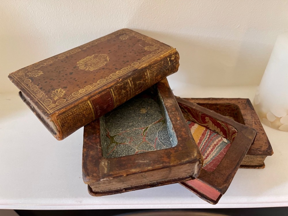 An antique novelty box crafted to resemble four French leather-bound book spines with gilt detailing and embossed text. View V