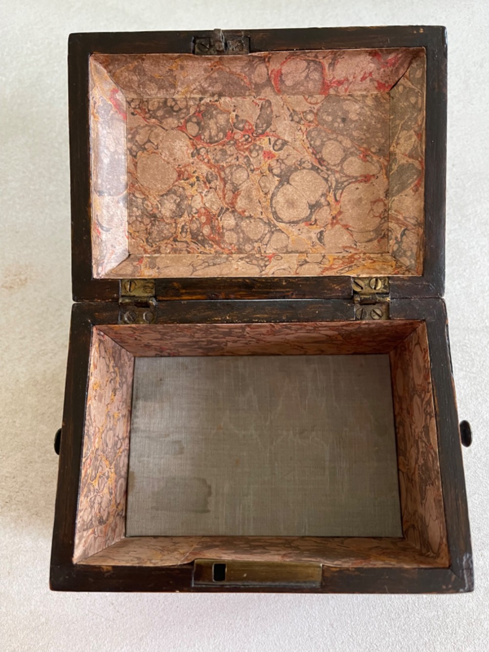 An antique rectangular rosewood box featuring a hinged lid, mother-of-pearl crescent corner inlays, and a central brass keyhole escutcheon. View IV