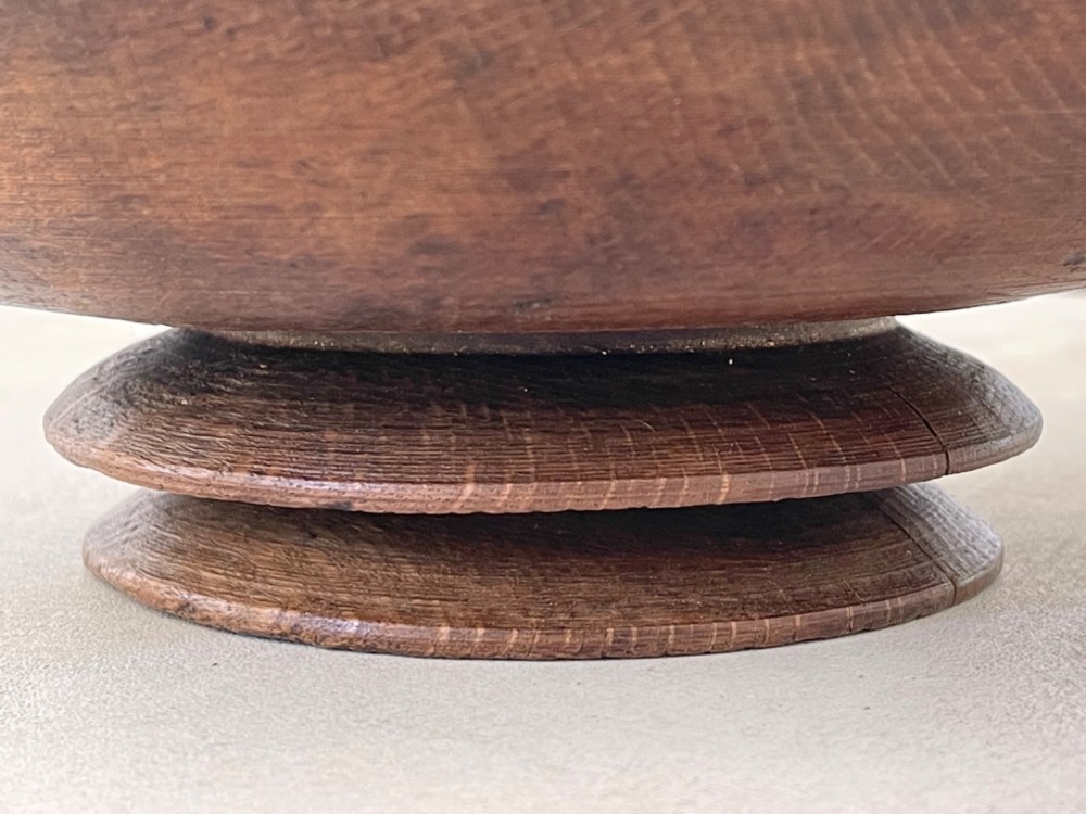 A turned dark wood pedestal bowl featuring a raised central anvil post and a stepped circular base. View II