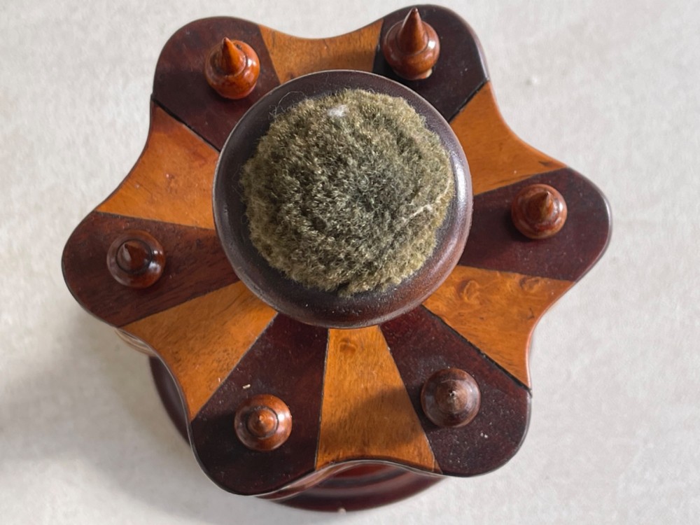 A turned dark mahogany cotton reel stand featuring a central pillar topped with a green fabric pin cushion and surrounded by brass spindles holding wooden thread spools. View V