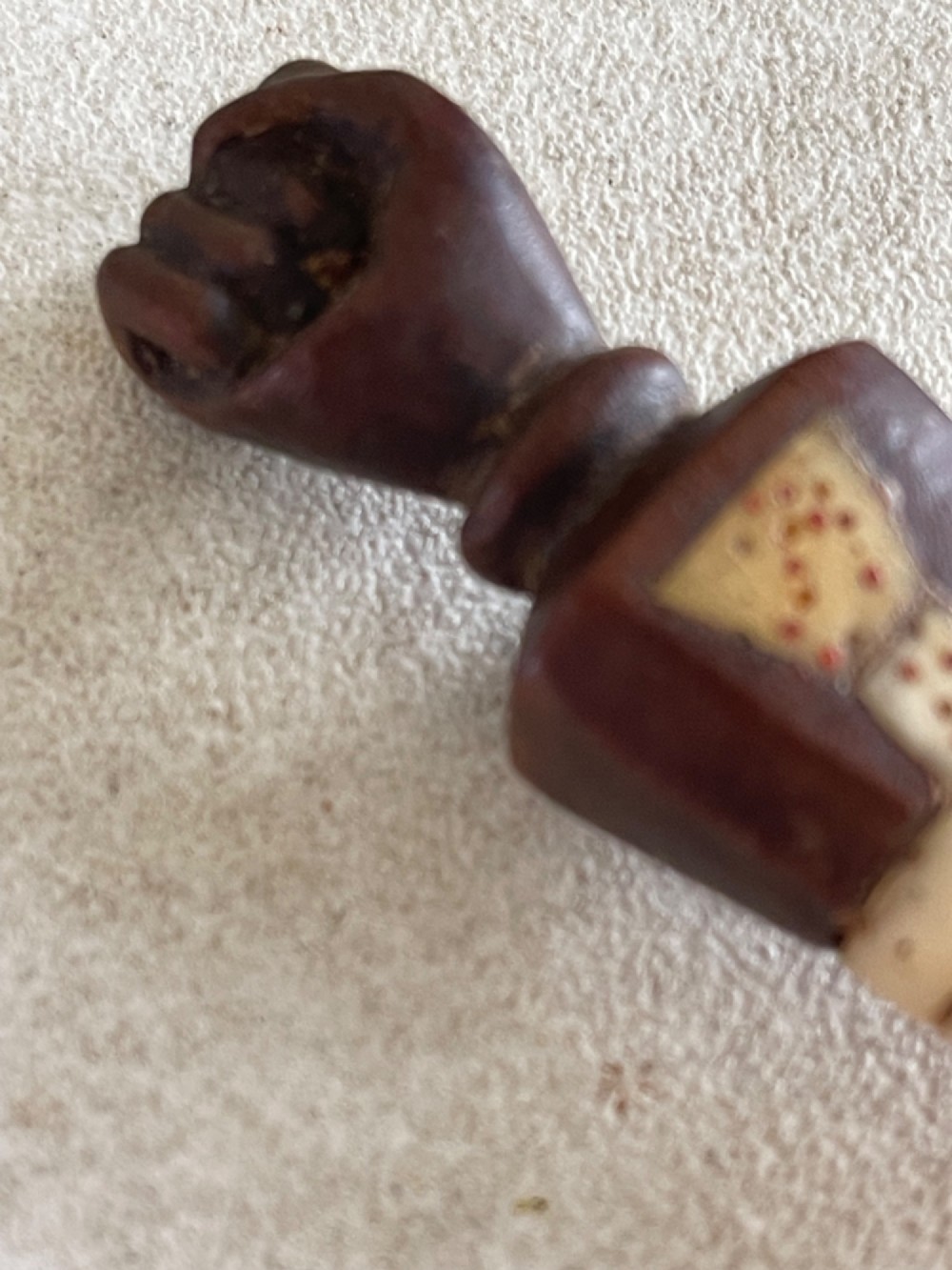 A carved antique bone and wooden apple scoop featuring a terminal in the shape of a clenched fist and carved lettering on the collar. View VI