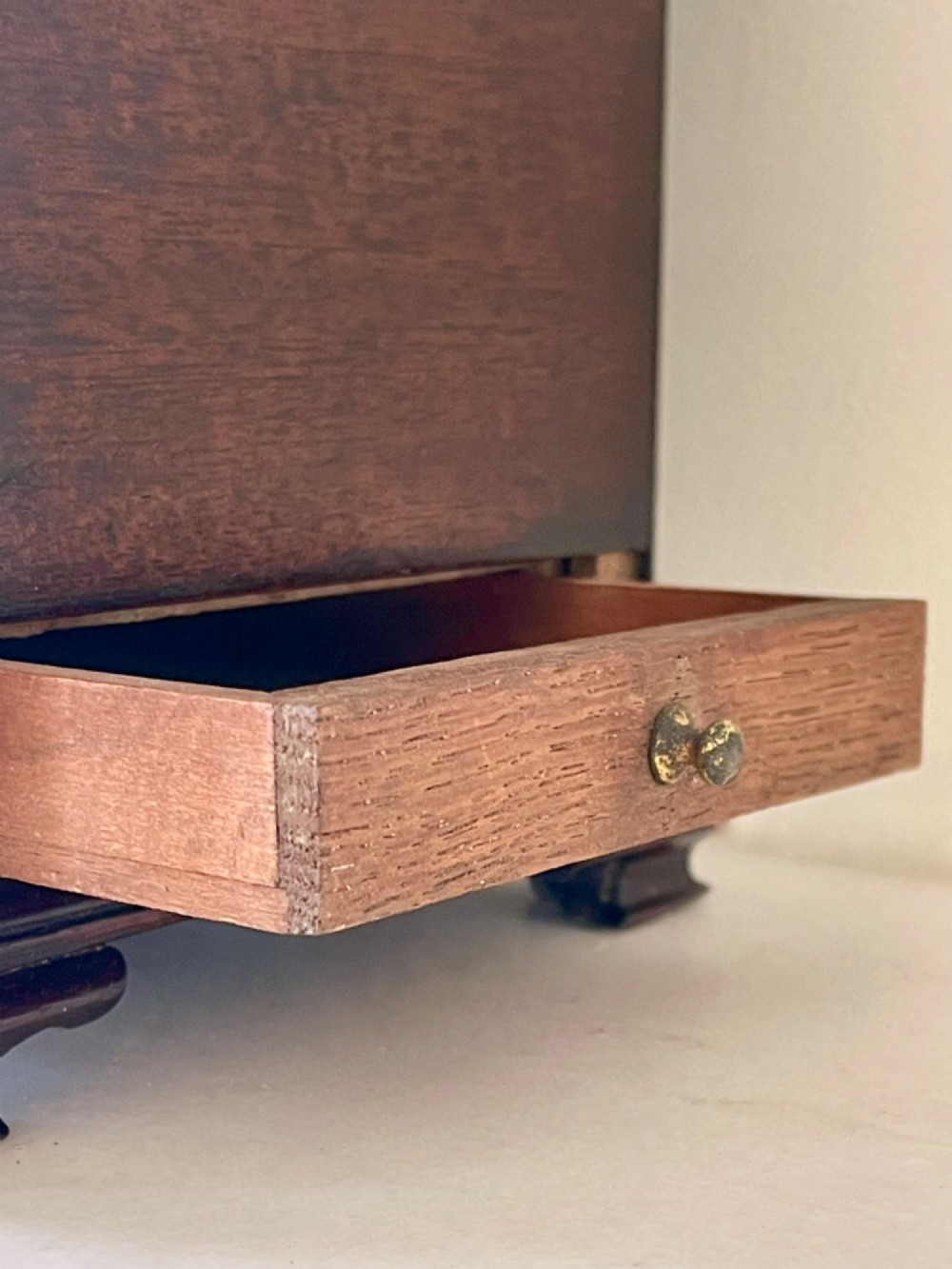 A Georgian dark mahogany tea chest with a stepped lid, brass top handle, ornamental brass escutcheon, and bracket feet. View II