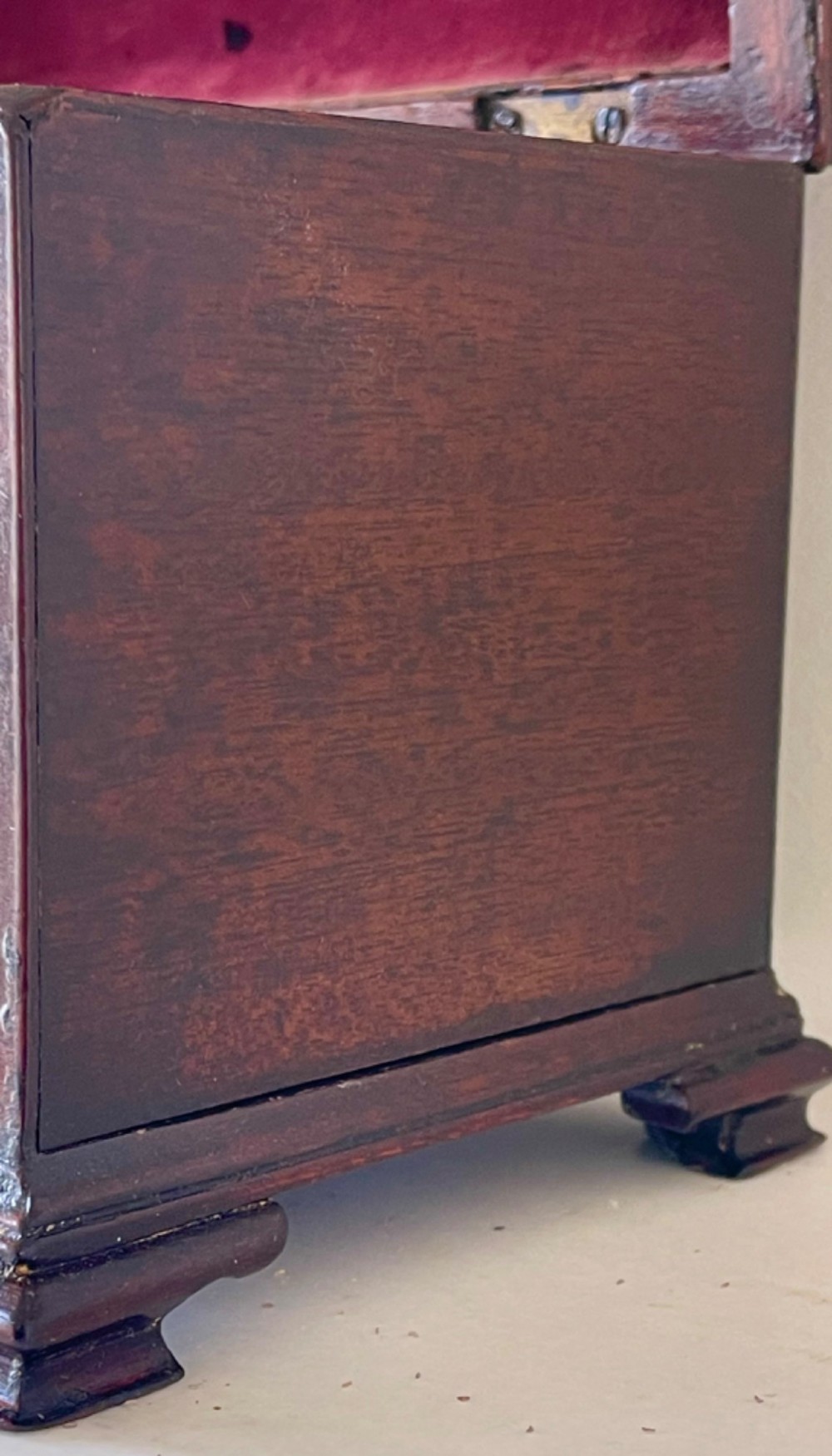 A Georgian dark mahogany tea chest with a stepped lid, brass top handle, ornamental brass escutcheon, and bracket feet. View V