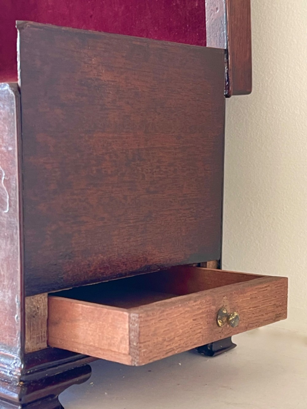 A Georgian dark mahogany tea chest with a stepped lid, brass top handle, ornamental brass escutcheon, and bracket feet. View VII