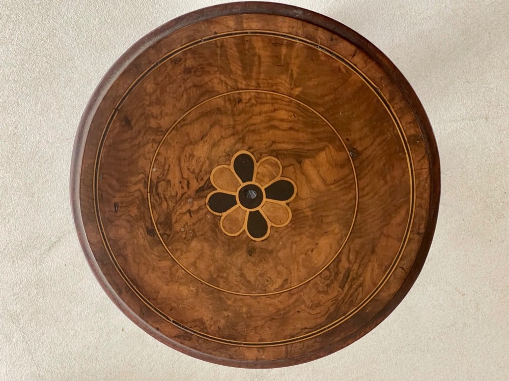 An antique circular tilt-top table featuring burr walnut veneer with a central floral marquetry inlay on a turned pedestal and triform base. View II