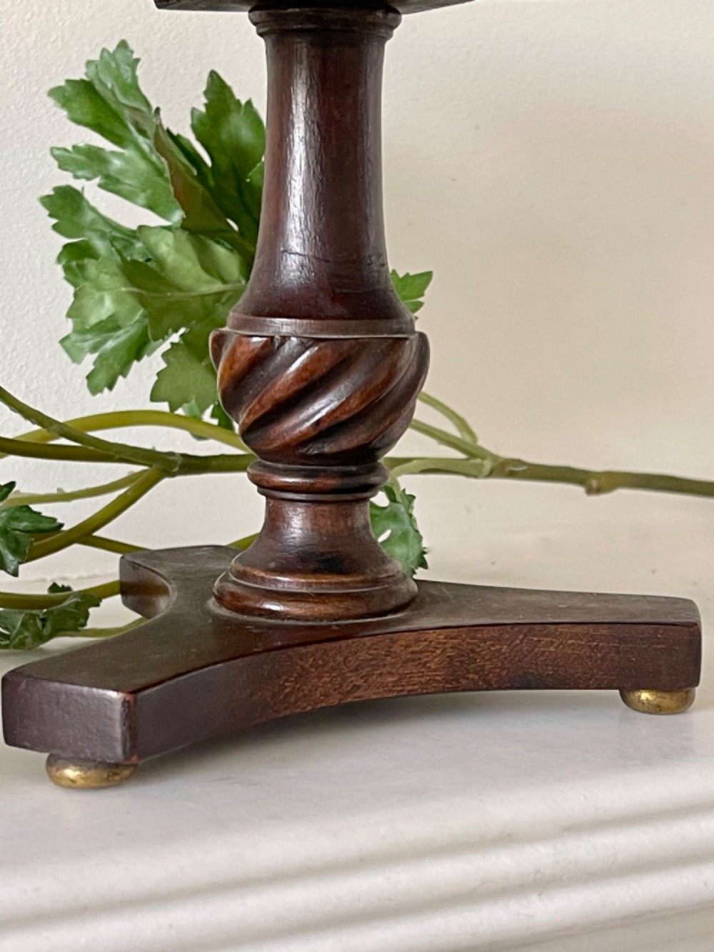 An antique circular tilt-top table featuring burr walnut veneer with a central floral marquetry inlay on a turned pedestal and triform base. View III