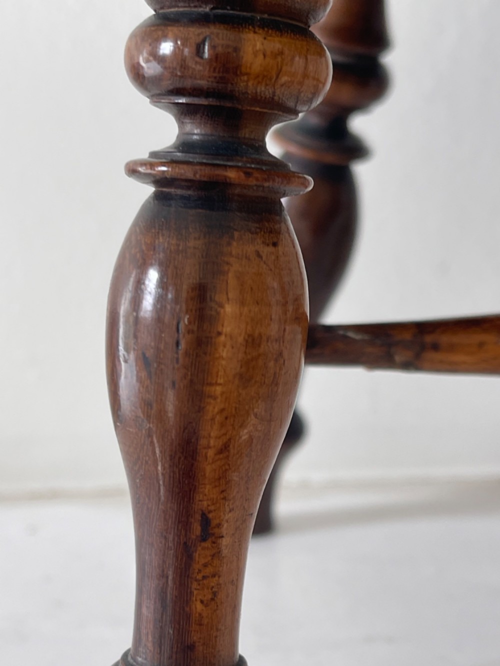 A miniature dark wood Windsor armchair featuring a shaped top rail, turned spindle back, sculpted armrests, and turned legs linked by stretchers. View III