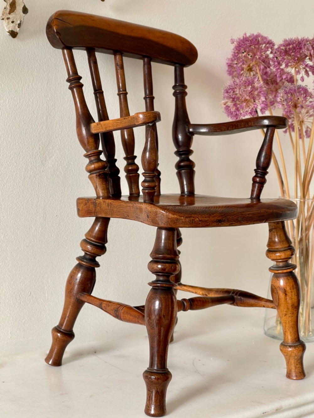 A miniature dark wood Windsor armchair featuring a shaped top rail, turned spindle back, sculpted armrests, and turned legs linked by stretchers. View IV