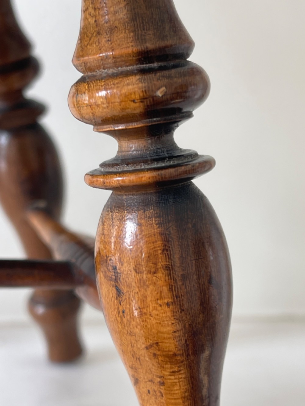 A miniature dark wood Windsor armchair featuring a shaped top rail, turned spindle back, sculpted armrests, and turned legs linked by stretchers. View V