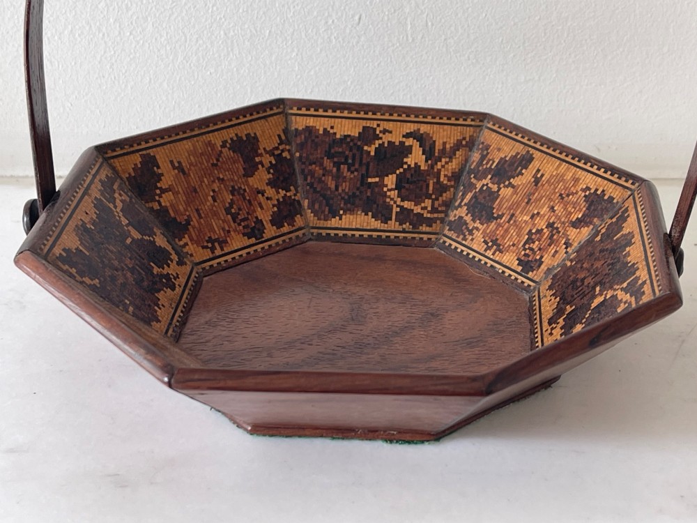 An octagonal Victorian Tunbridge ware wooden sewing basket with a curved overhead handle and floral wood mosaic inlay along the interior panels. View II