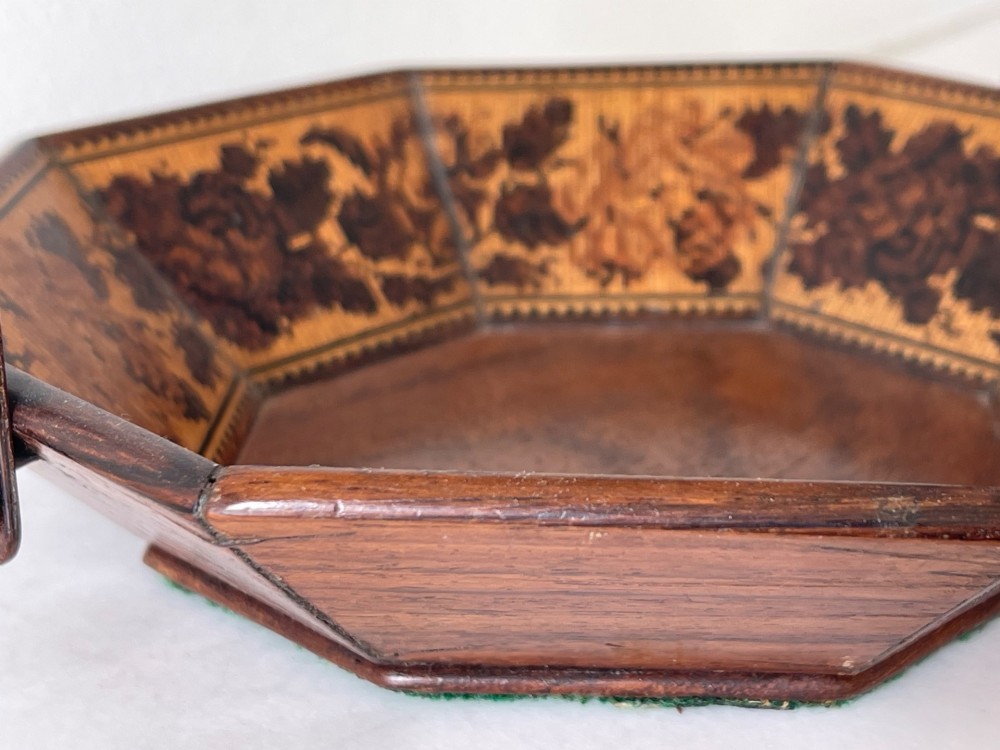 An octagonal Victorian Tunbridge ware wooden sewing basket with a curved overhead handle and floral wood mosaic inlay along the interior panels. View V