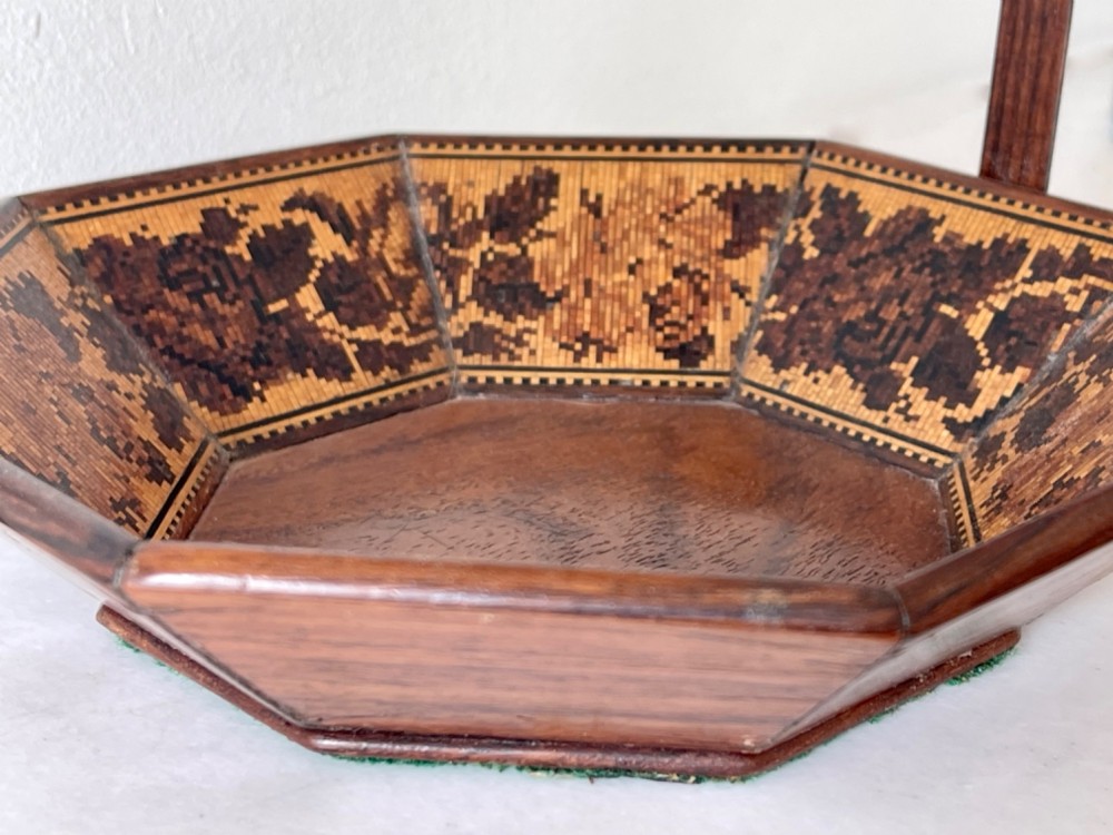 An octagonal Victorian Tunbridge ware wooden sewing basket with a curved overhead handle and floral wood mosaic inlay along the interior panels. View VI