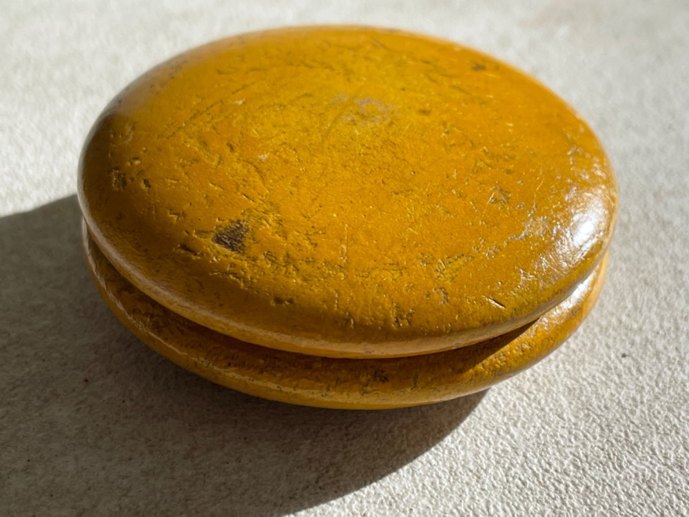 A circular yellow wooden antique Scottish snuff box with a printed love poem on the top lid. View II